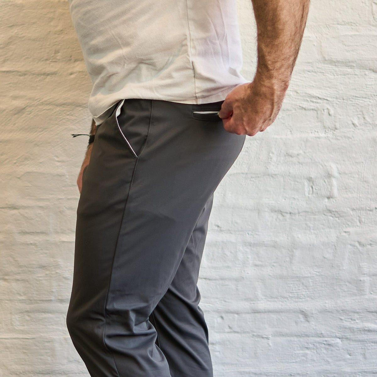 Close-up of tailored grey trousers showing the waist and side profile