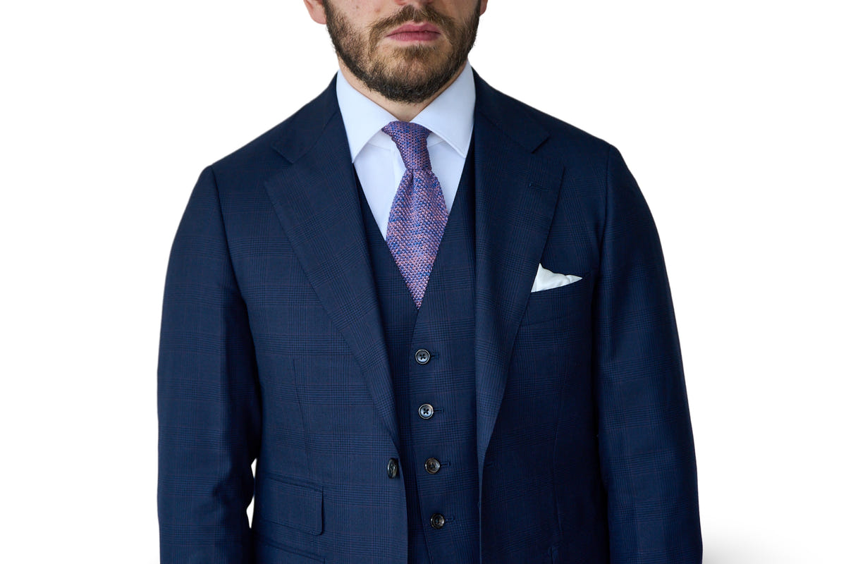 Navy three-piece suit with a white shirt and patterned tie
